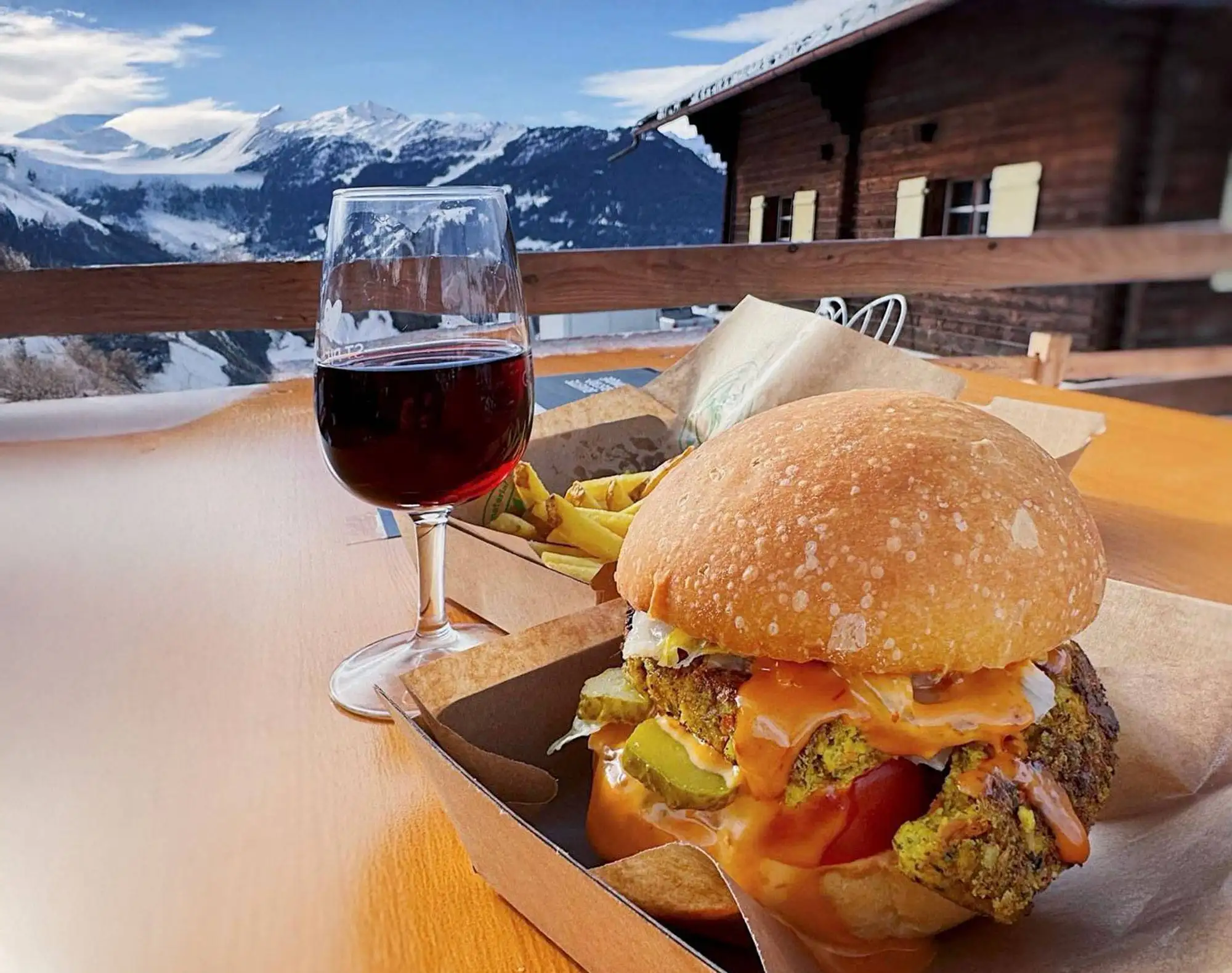 Burger et vin rouge en terrasse, Verbier